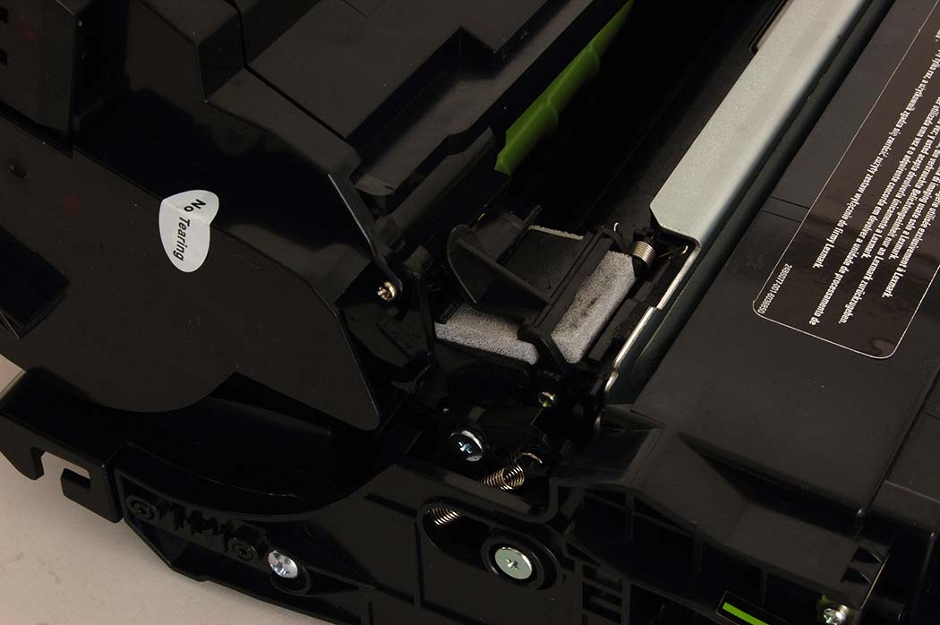 Toner cartridge supply port beginning to slide under flap on imaging unit (normally done inside the printer)